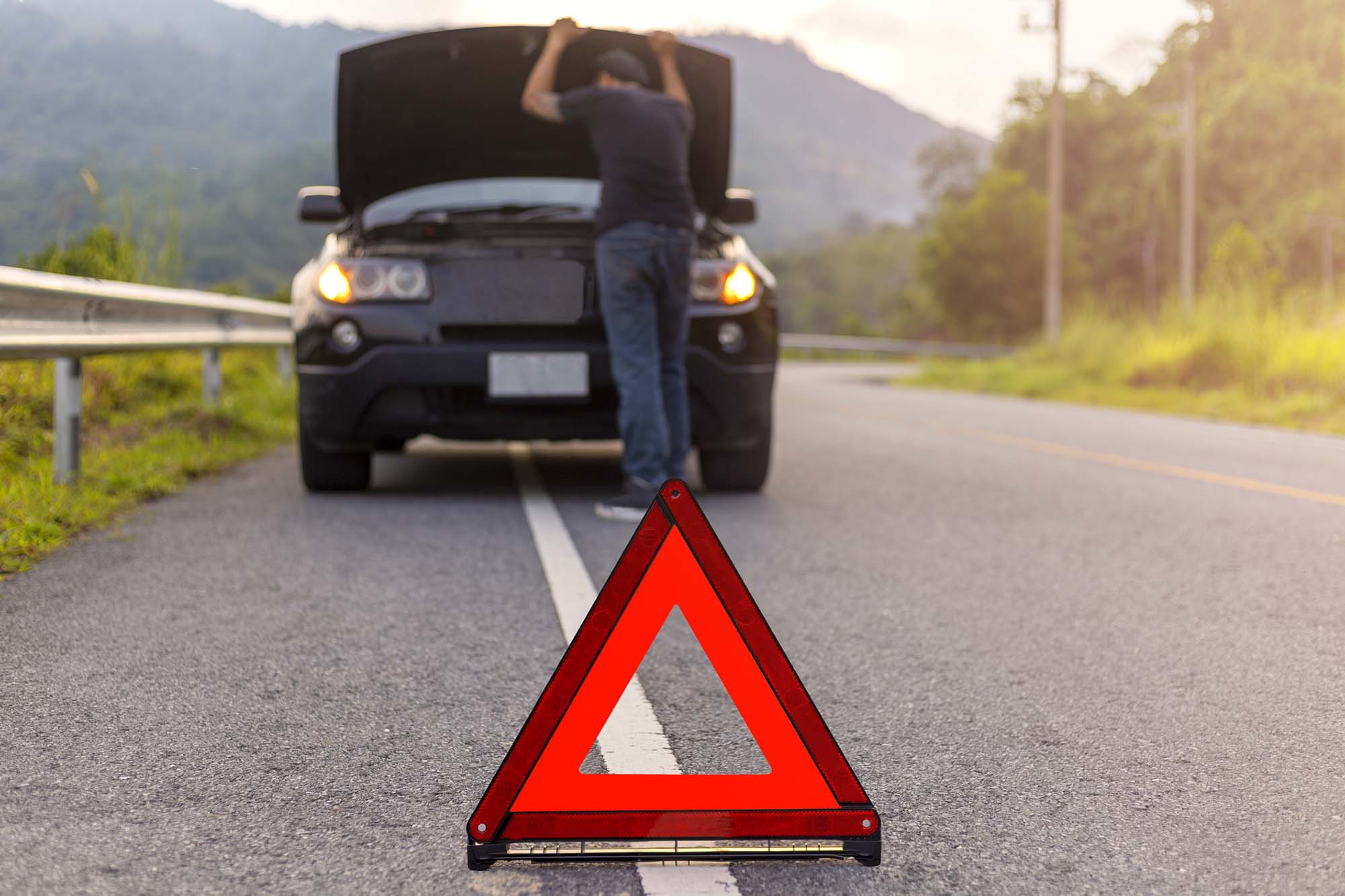 Breakdown Recovery sign on road with man checking engine